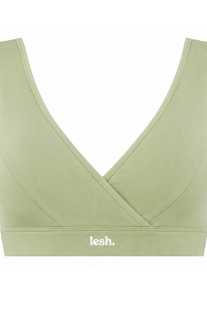 A sage green wireless sports bra with a crossover wrap front and a white 'lesh.' logo printed on the underband, shown against a plain white background.