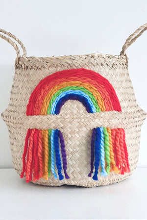 Vivid Rainbow Belly Basket, front view of woven basket with two handles and a woven rainbow with tassels