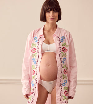 Pregnant woman wearing pink lounge shirt