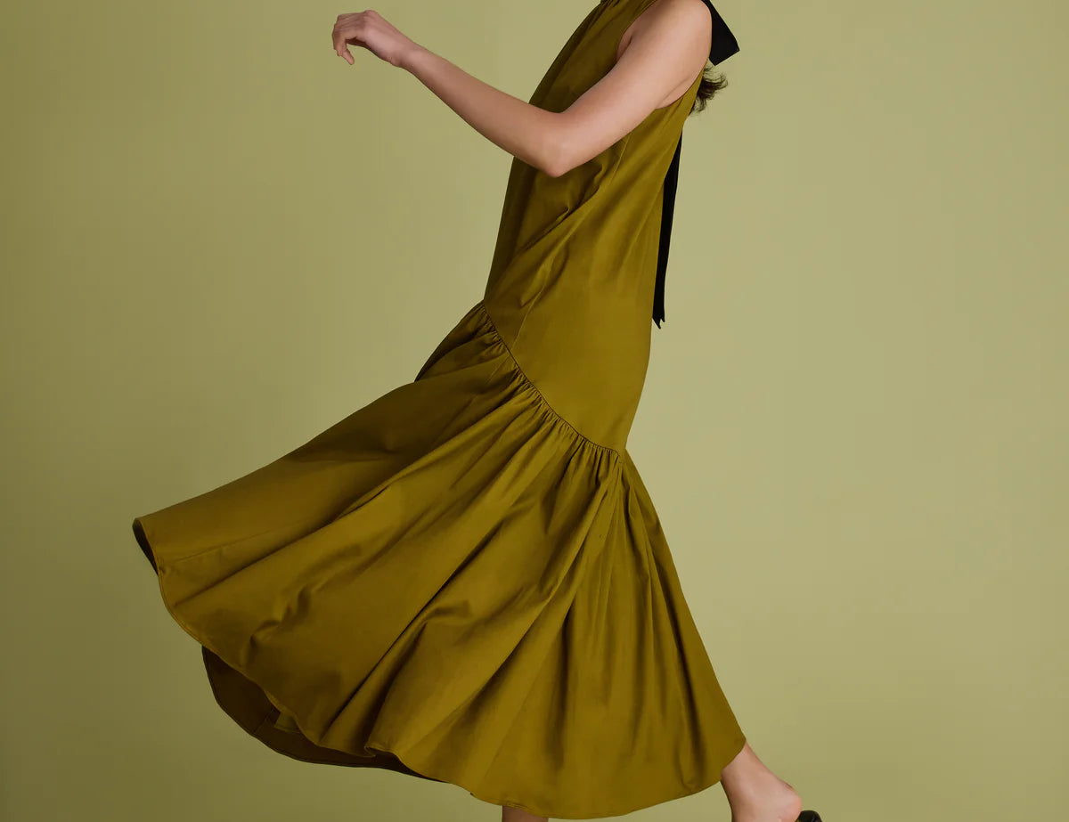 Woman wearing a green dress on a matching background
