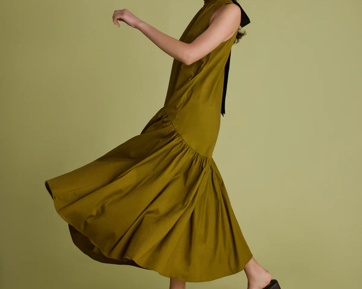 Woman wearing a green dress on a matching background
