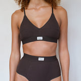 A model wearing a dark brown two-piece bikini set with a scoop neck top and high-waisted bottoms, featuring a small white brand label that reads 'HENDT'.