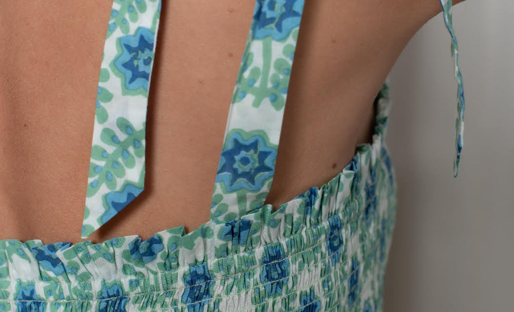 Close-up of a floral dress with shoulder tie design.