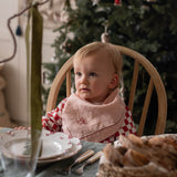 Child at christmas table with napkin around their neck