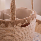 Close-up of a woven basket with a handle and visible brand label.