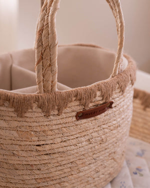 Close-up of a woven basket with a handle and visible brand label.