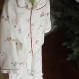 White pajama set with red piping and small prints on a dark background