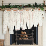 Set of children's pajamas hanging on a fireplace mantle with decorative elements.