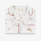 A folded white pajama set with red piping and a small woodland print, tied with a light pink ribbon printed with the brand name 'Avery Row'.