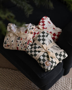 Three wrapped gifts with festive patterns on a black surface.