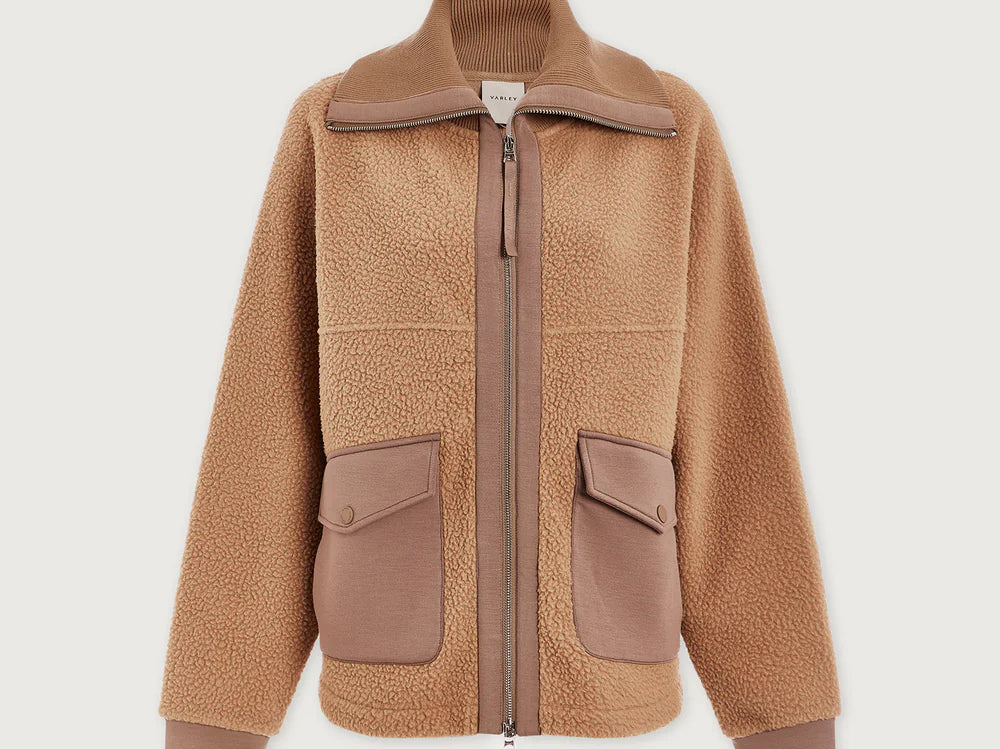 Model wearing Varley Eleanor Patch Pocket Fleece in soft borg fabric with DoubleSoft® trims and front zip.