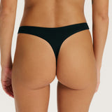 Black thong worn by a person on a plain background