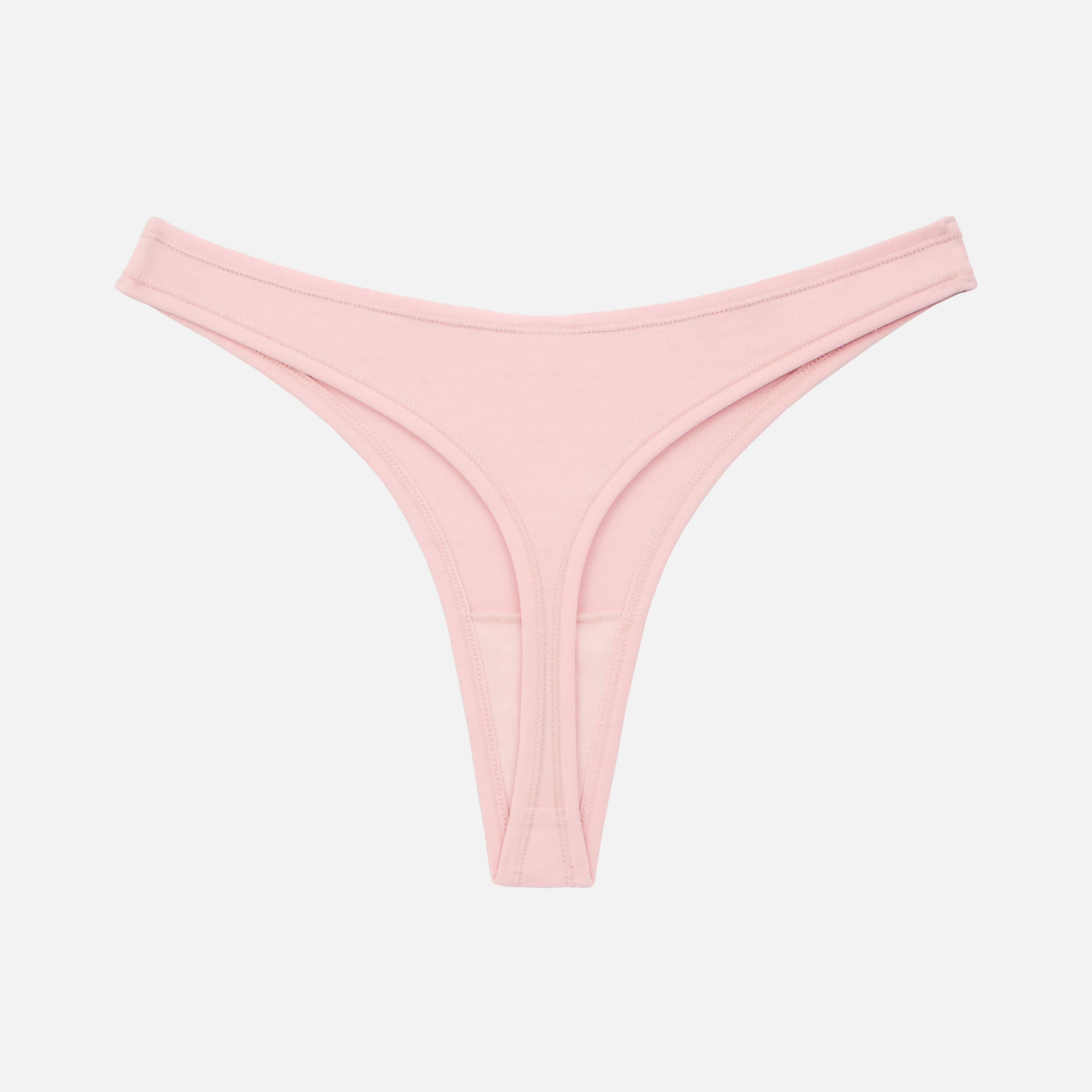 A light pink ribbed thong-style bikini bottom with a wide waistband and minimal side straps, shown flat against a light gray background.