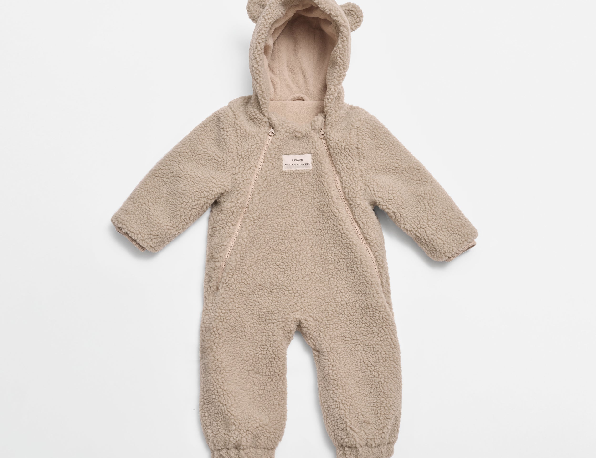ALF Eco Pramsuit in beige, front view laid flat showing the hood with bear ears, diagonal zip and cuffed legs