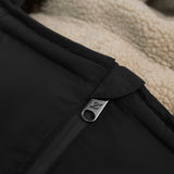 Alma Eco Quilted Footmuff Black, close-up of the metal zip pull and cream fleece lining