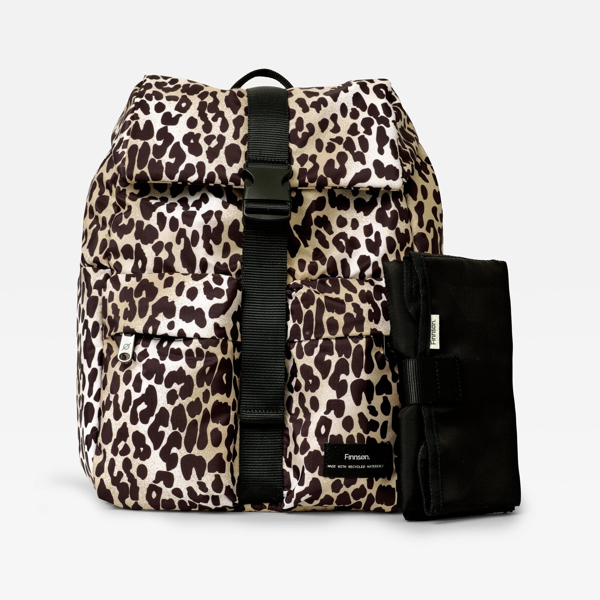 Elise Eco Changing Backpack Leopard, front view with black buckle strap and folded black changing mat beside it