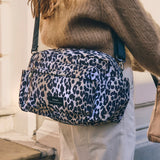 Freya stroller organiser in Leopard worn crossbody over a brown knit jumper