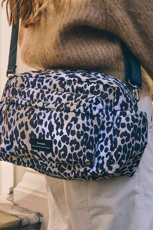 Freya stroller organiser in Leopard worn crossbody over a brown knit jumper