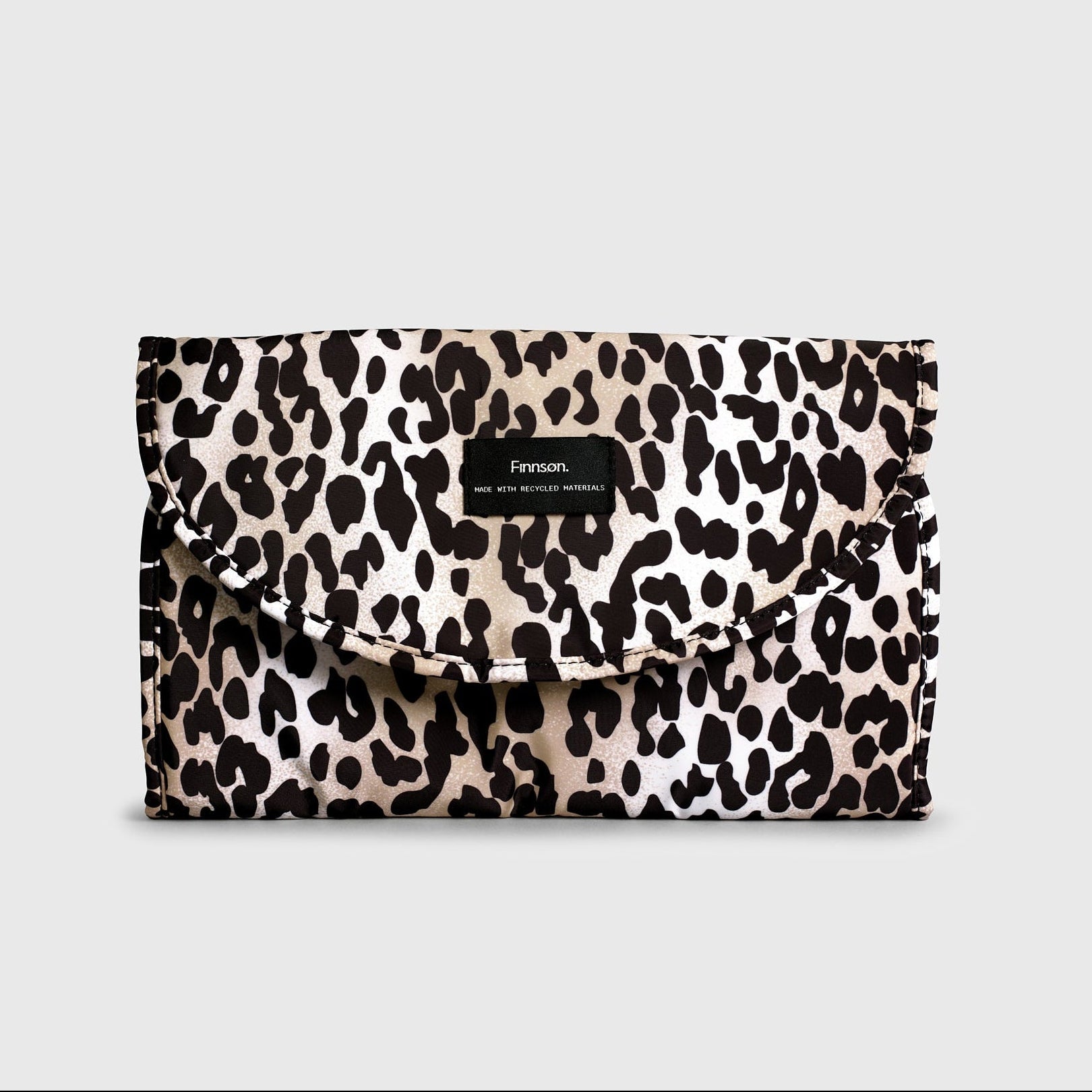 Oslo Eco Travel Changing Mat in Leopard, folded closed with a black Finnson label on the front flap