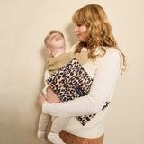 Oslo Eco Travel Changing Mat in Leopard worn across the body by a woman holding a baby against her shoulder