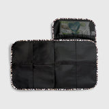 Oslo Eco Travel Changing Mat in Leopard unfolded flat, showing the black quilted mat and a mesh pocket