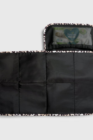Oslo Eco Travel Changing Mat in Leopard unfolded flat, showing the black quilted mat and a mesh pocket