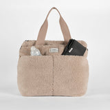 Sigrid Eco Changing Bag beige front view with a baby bottle and folded black changing mat tucked in the front pockets