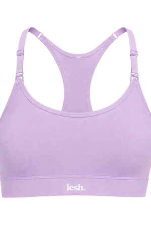 A light purple racerback sports bra with adjustable shoulder straps and a white 'lesh.' logo printed on the underband, shown against a plain white background.