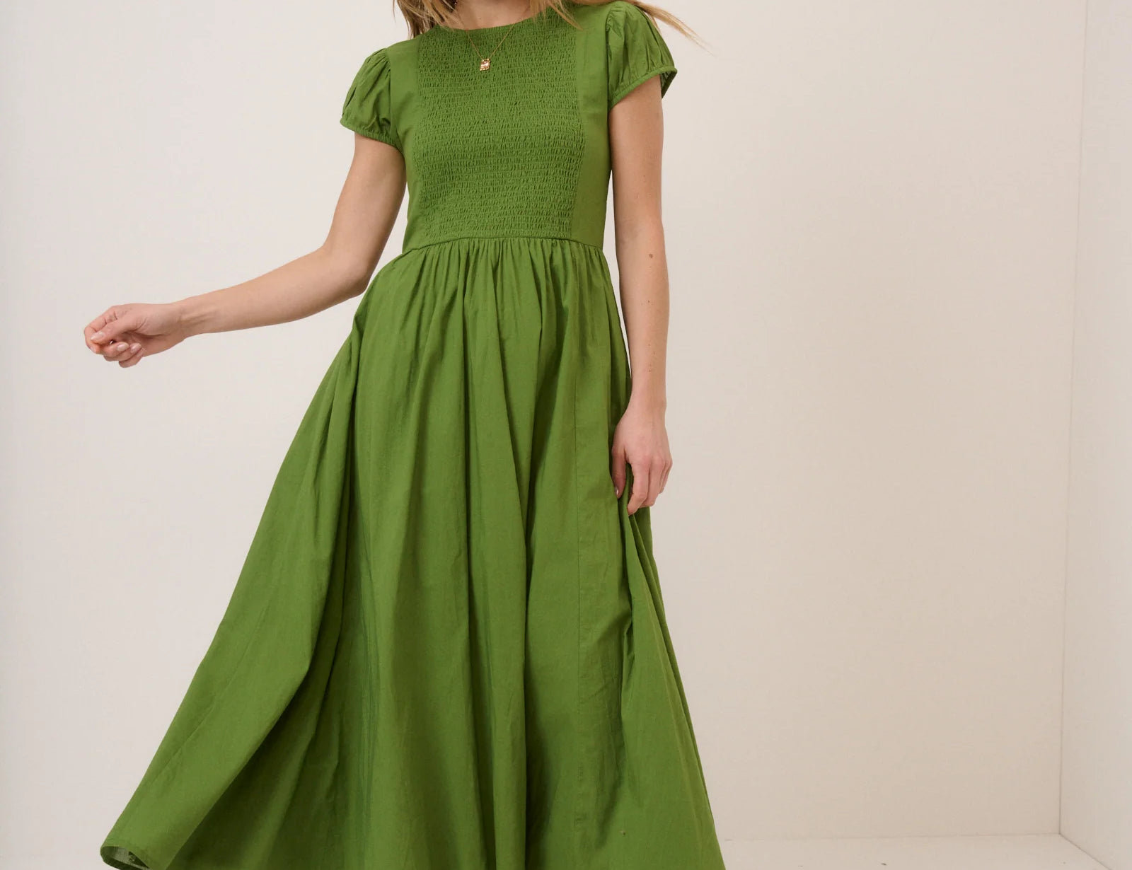 Woman wearing a green dress against a white background