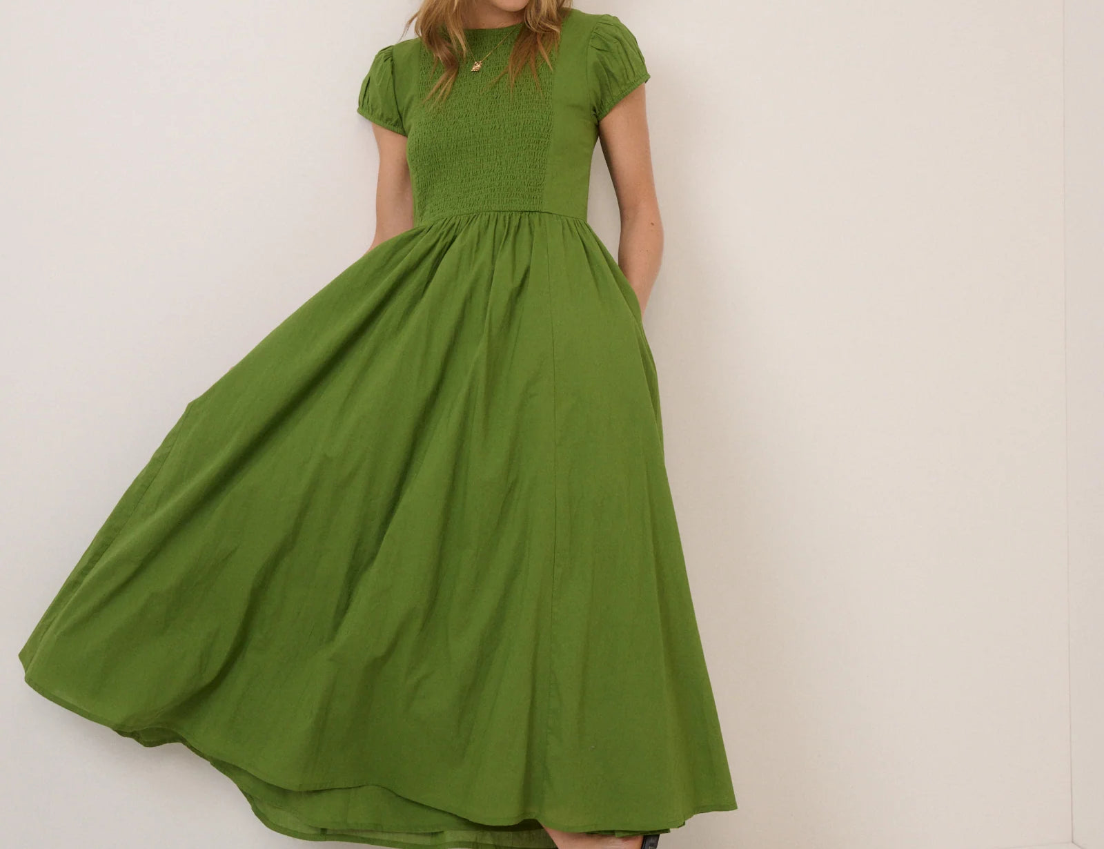 Woman wearing a green dress against a white background