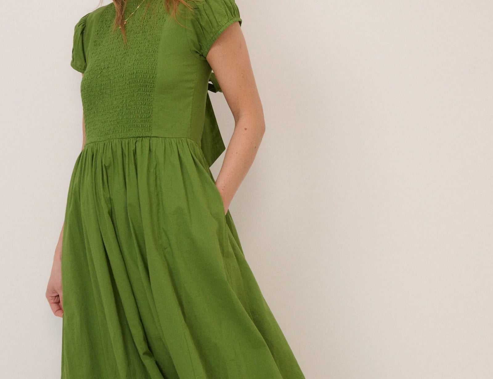 Woman wearing a green dress against a white background