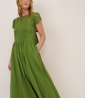 Woman wearing a green dress against a white background