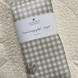 Folded checkered mat with a label on a textured surface
