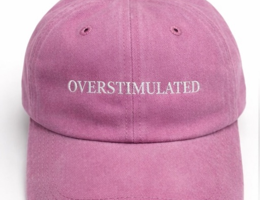 Pink cap with 'OVERSTIMULATED' text on a white background