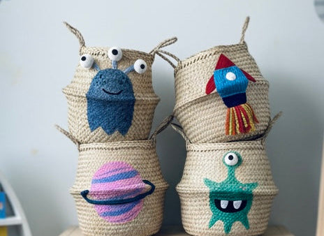 Blue Alien Basket stacked with a planet, rocket and green alien basket on a wooden shelf in a space-themed nursery