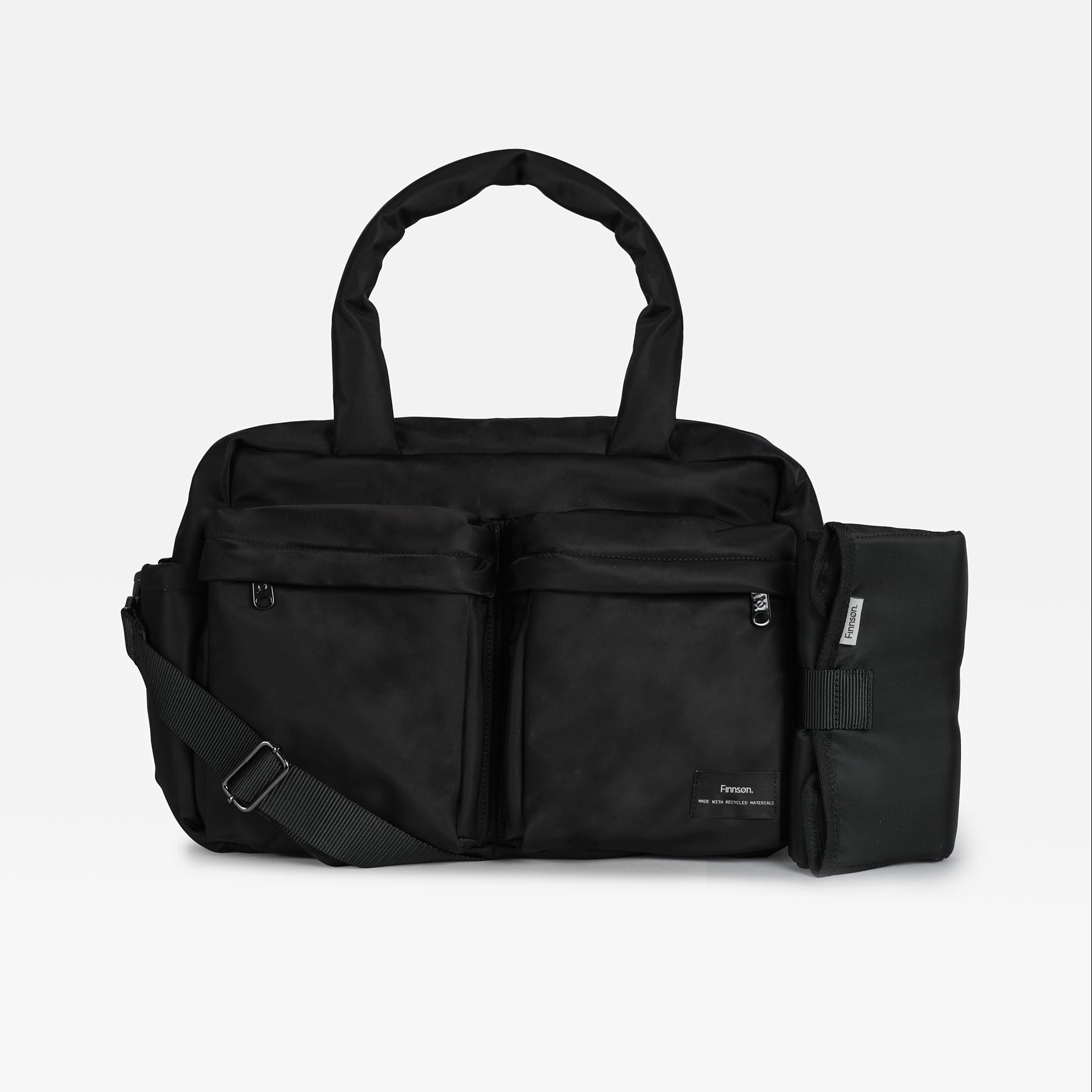 A black multi-compartment duffel bag with a detachable shoulder strap and an attached black pouch on the side, shown against a light gray background.