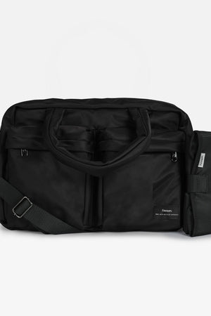 A black nylon duffel bag with a detachable shoulder strap and an attached black side pouch, shown against a plain light gray background.