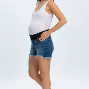 Woman wearing a white tank top and denim shorts on a white background