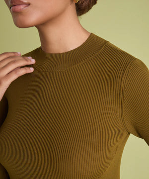 Close-up of a model wearing a ribbed short-sleeve crewneck top in a warm olive-brown color, set against a solid pale yellow-green background.