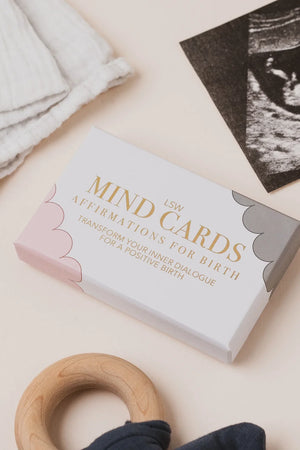 Box of 'Mind Cards' affirmations for birth on a light background with a wooden ring and ultrasound photo.