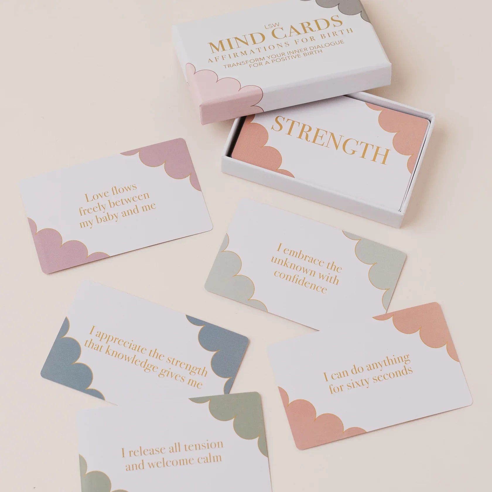 A boxed set of affirmation cards arranged on a light cream background. The white box is labeled 'MIND CARDS AFFIRMATIONS FOR EIGHTH' and one card is pulled out reading 'STRENGTH.