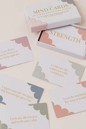 A boxed set of affirmation cards arranged on a light cream background. The white box is labeled 'MIND CARDS AFFIRMATIONS FOR EIGHTH' and one card is pulled out reading 'STRENGTH.