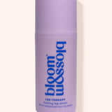 A lavender purple cylindrical bottle of bloom & sojo Leg Therapy Cooling Leg Serum, featuring blue text on a light beige background.