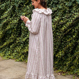Beatrice Rose Stripe nightie back view on a woman by an ivy wall, showing the ruffled collar and tiered hem