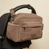 Freya Eco Stroller Organiser in Mocha Borg hanging from the black handlebar of a pushchair, front pocket facing out