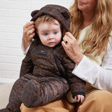 ANDERS Eco Snowsuit Chocolate Leopard worn by a baby sitting on a woman's lap while she adjusts the hood