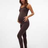 A pregnant woman modeling a dark brown maternity bodysuit and matching leggings against a clean white studio background.