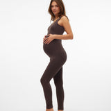 A pregnant woman modeling a dark brown sleeveless bodysuit and matching leggings against a plain white studio background.