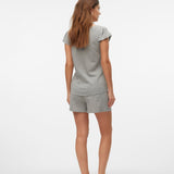 Woman wearing a gray pajama set on a white background