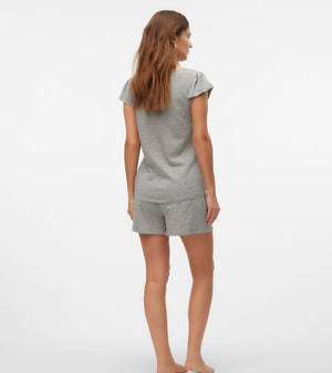 Woman wearing a gray pajama set on a white background